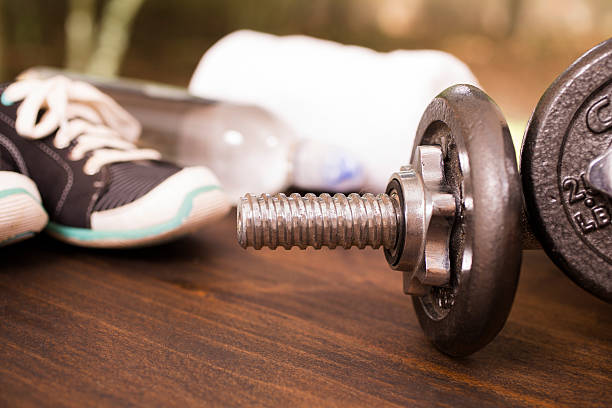 istock Fitness, exercise themed scene with barbells, sneakers, water. 598716100