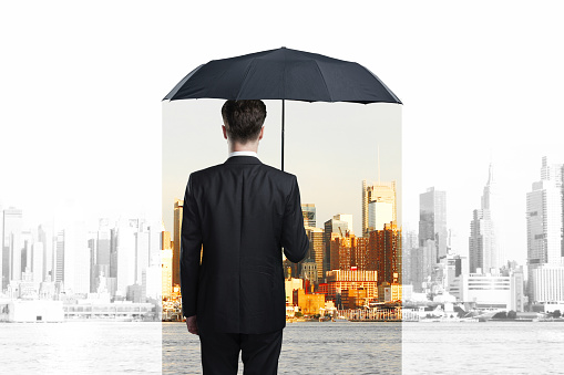 businessman with umbrella looking on city