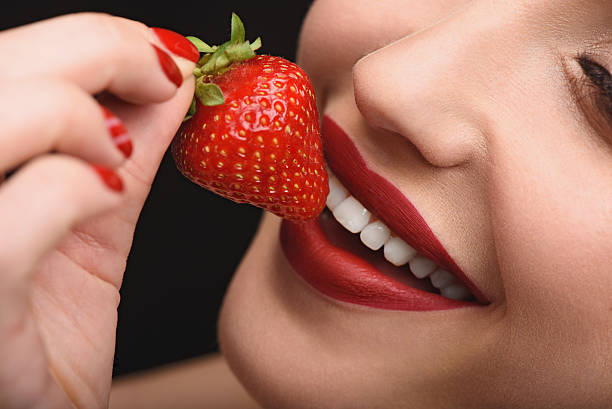 istock Joyful woman tasting sweet red berry 598785812