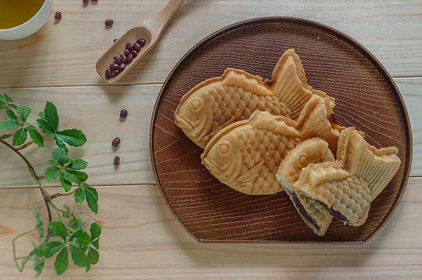 Taiyaki-a Japanese fish-shaped cake Taiyaki is a Japanese fish-shaped cake.  The most common filling is red bean paste that is made from sweetened azuki beans adzuki bean photos stock pictures, royalty-free photos & images