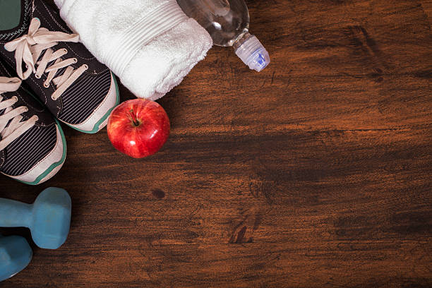 istock Fitness, exercise themed scene with weights, sneakers, apple. 598789414