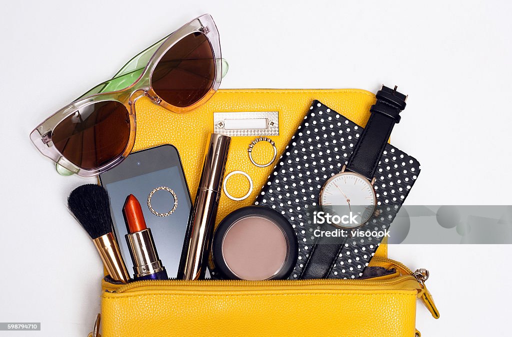 Top view trendy accessories for woman Top view trendy accessories for woman. Fashion sunglasses, yellow bag , watch , mascara , smart phone, rings Personal Accessory Stock Photo