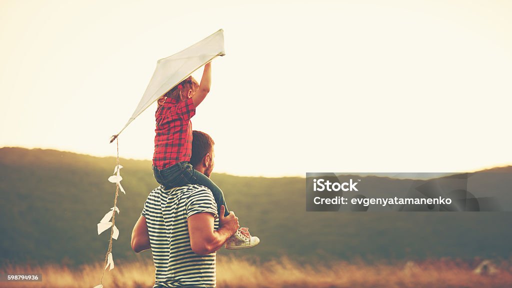 felice padre di famiglia e bambino sul prato con un aquilone - Foto stock royalty-free di Stili di vita