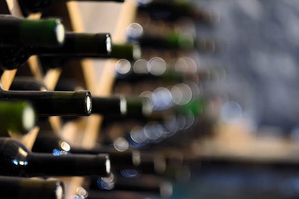 Wine bottles stacked on wooden racks stock photo