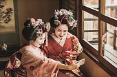 スマートフォンを使って自撮りする着物の2つの日本の舞妓