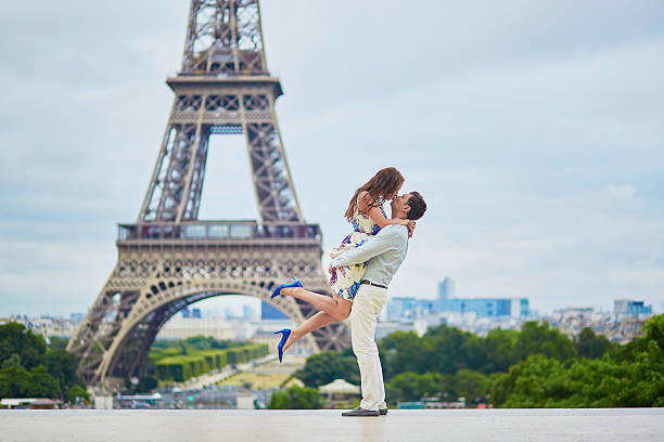 romantic loving couple having a date near the eiffel tower - paris france eiffel tower love kissing imagens e fotografias de stock