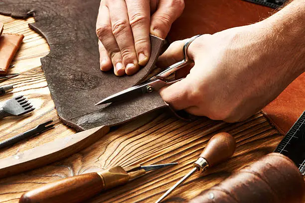 Man working with leather using crafting DIY tools