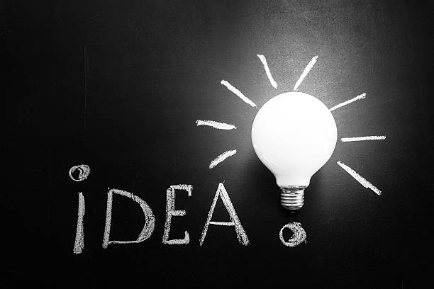 istock Light bulb  on the black chalkboard with title idea! 598802522