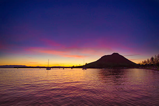 Sunset in harbour with boats and mountain Sunset at Pilot Bay, Mount Maunganui, New Zealand mount maunganui stock pictures, royalty-free photos & images