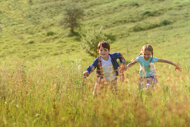 istock Boy and girl running on field 598805986