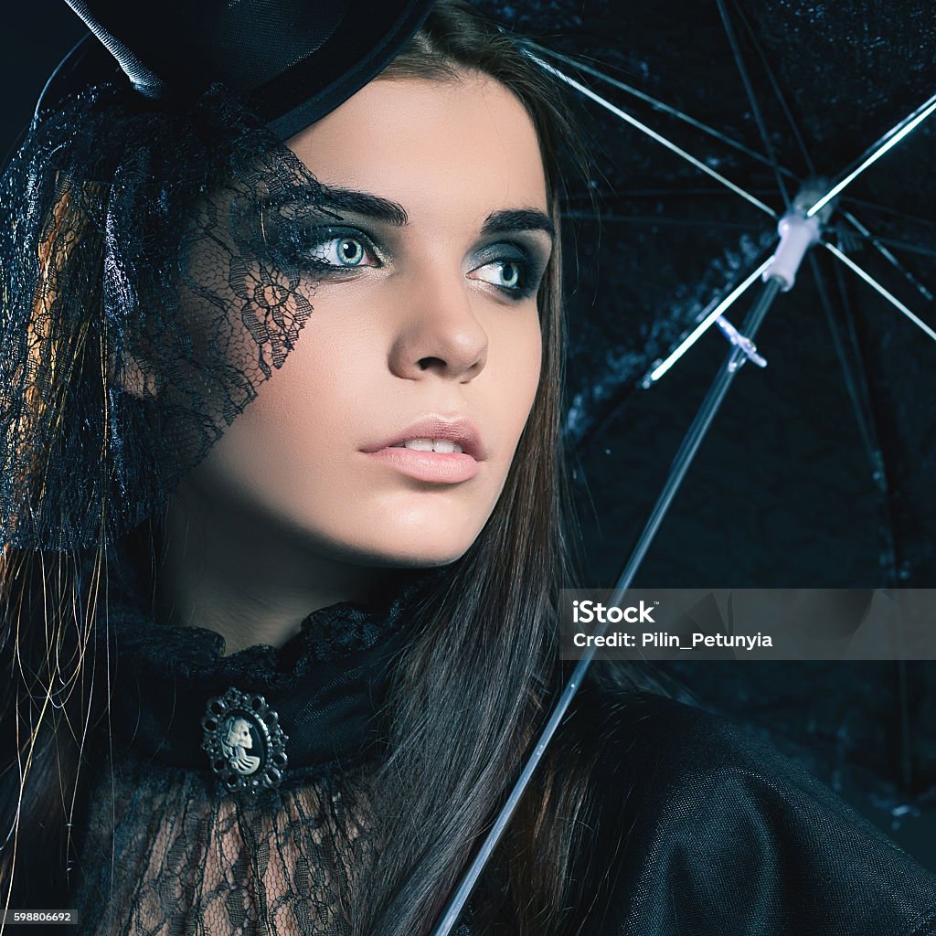 Halloween party 2016! Beautiful woman like doll Fashion young woman going to Halloween party 2016! Beautiful woman like doll with umbrella and hat. Halloween costumes. Role. Witch carnival costume. Role-playing games. Sexy girls. Night club 2016 Stock Photo