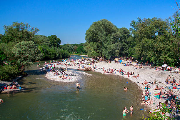 Munich, Germany - June 4, 2015: The Isar river in Munich with many unidentified people on a sunny day taking a sunbath