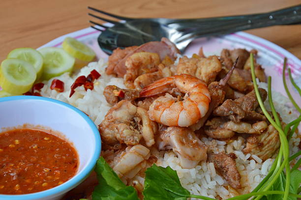 istock fried seafood and meat with garlic on plain rice 598809186