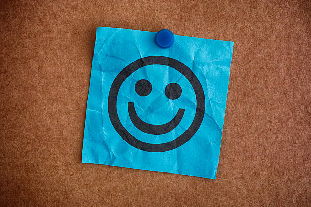 Blue paper note with happy face Blue paper note with happy face. Close up. smiley face postit stock pictures, royalty-free photos & images