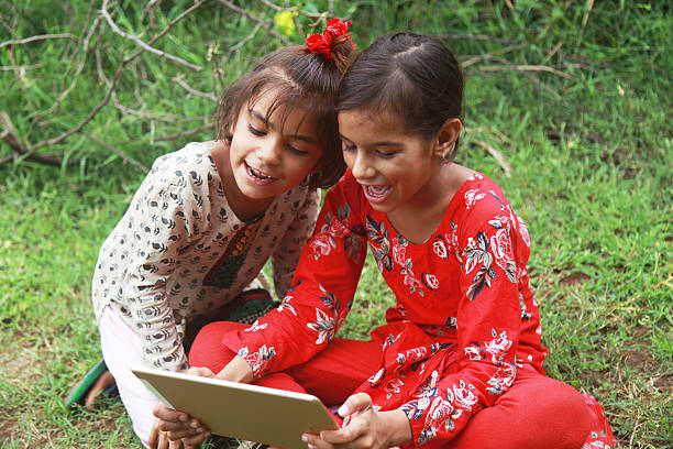 istock Two small village girls holding digital tablet 598811268