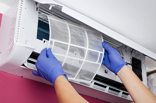istock Air conditioner cleaning. Man checks the filter. 598811392