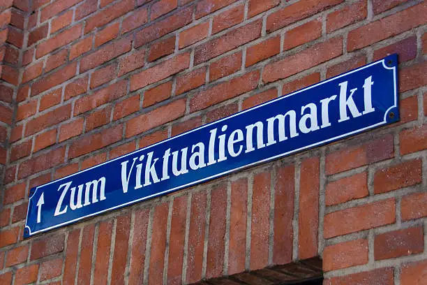 Blue white street sign of Viktualienmarkt on a brick building