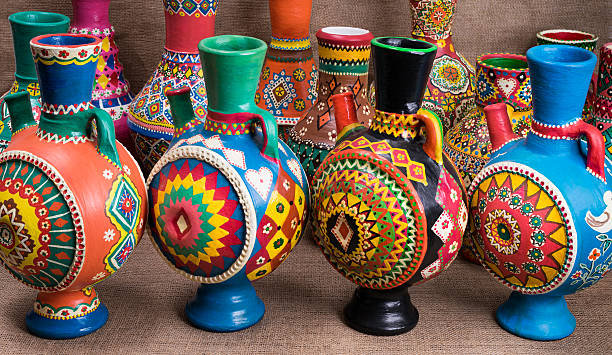 istock Four decorated colorful handcrafted pottery jugs on sackcloth background 598814354