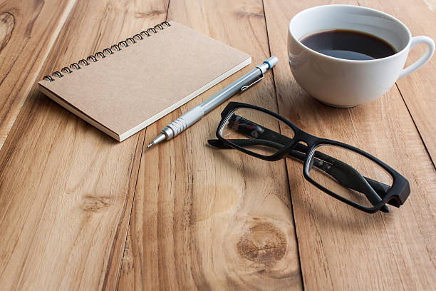 istock office table with glasses, pencil and note book, business concep 598815928