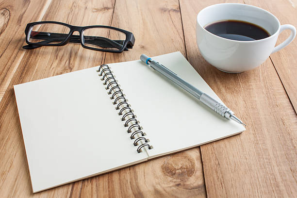 istock office table with glasses,  pencil and open notebook, business c 598816154