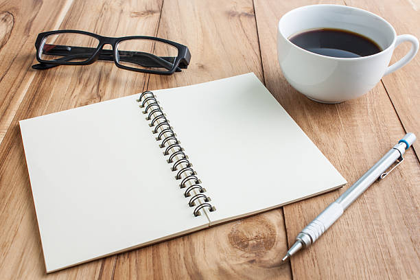 istock office table with glasses,  pencil and open notebook, business c 598816376