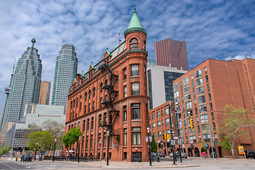 City view of the Gooderham Building or Flatiron Building and financial district of Toronto. At the left side the CN Tower can be seen partially.