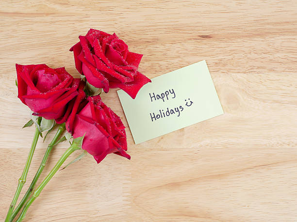 istock Handwritint Happy Holidays and res rose flower 1 598820430
