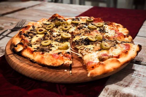 Sliced home made pizza on wooden rustic background