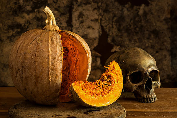 istock Still Life Skull and pumpkin on the table. 598822650
