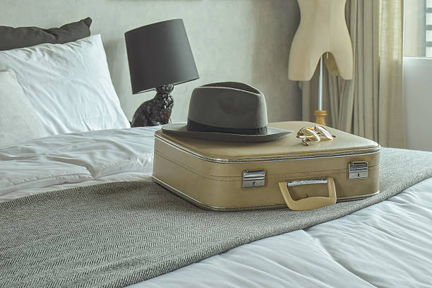 istock Retro bag, hat and sunglasses on bed in hotel guest 598824702