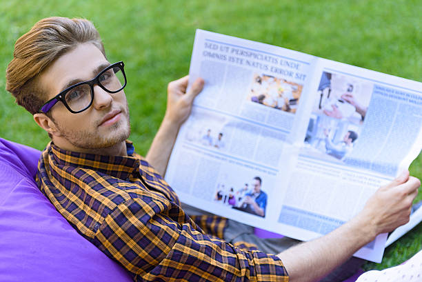 istock Carefree guy reading paper outdoors 598827480