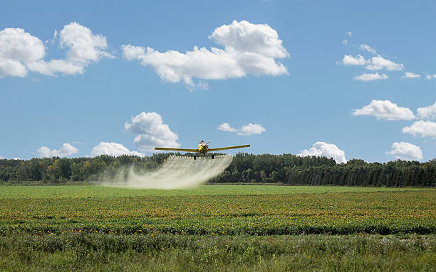 spruzzare sostanze chimiche in piano spruzzando sul campo. - spraying agriculture farm herbicide foto e immagini stock