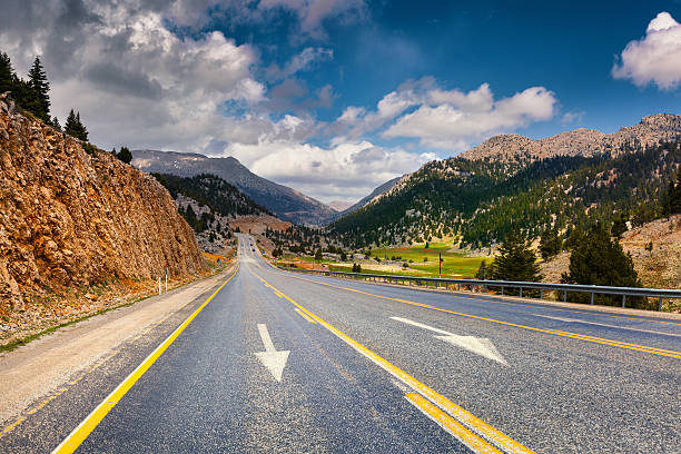 istock Empty asphalt road with dramatic cloudy sky. Beautiful outdoor s 598829190