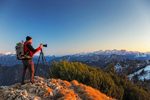 nature photographer with tripod an backpack  in the alps - nature photographer imagens e fotografias de stock