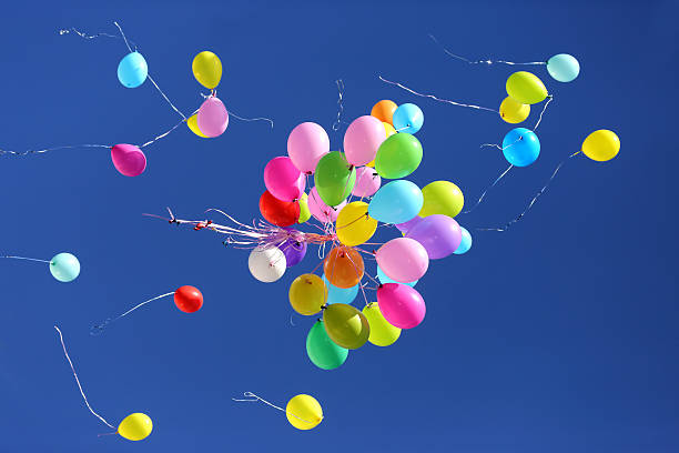 istock many multicolored balloons flying in the blue sky 598913314