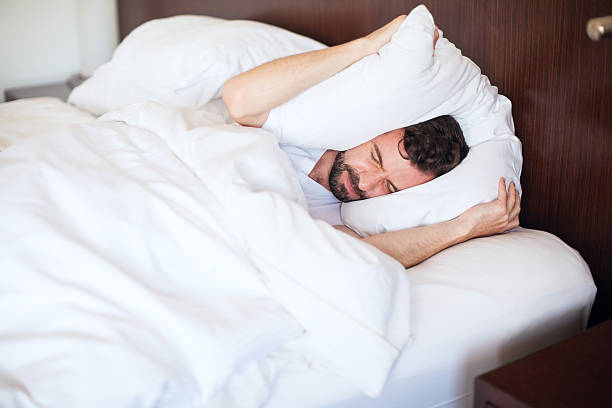 istock Man can't sleep due to the noise 598915392