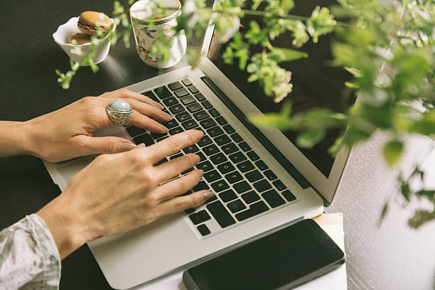 istock Woman hands writes a pen in a notebook, computer keyboard 598915992