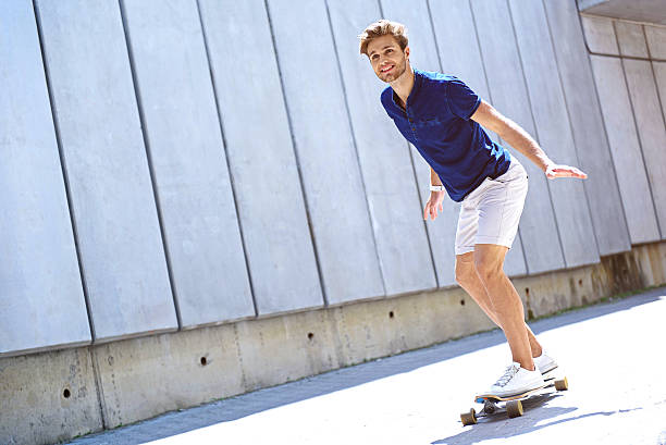 istock Happy guy skateboarding on street 598918758