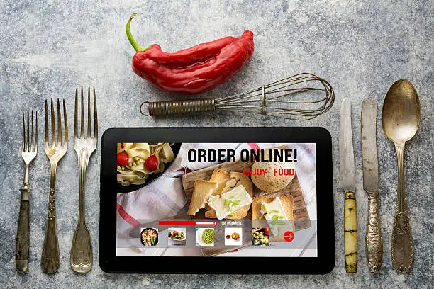 Photo of Tablet with Online food delivery app on screen. lifestyle concep