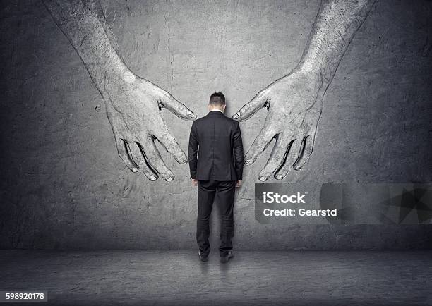 Back View Of A Businessman Standing Between Big Hand Drawn Stock Photo - Download Image Now