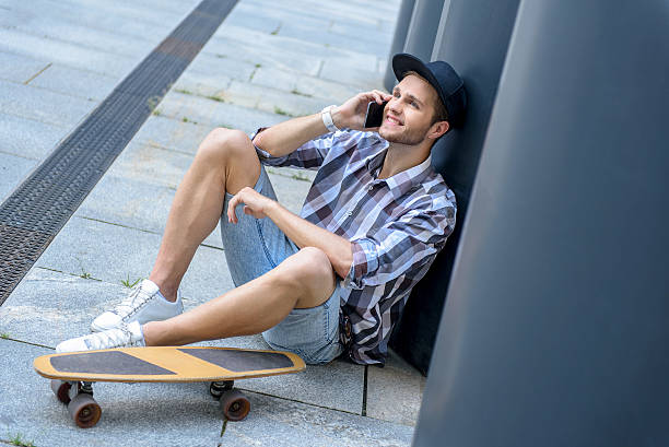 istock Cheerful male skater using smartphone 598929468