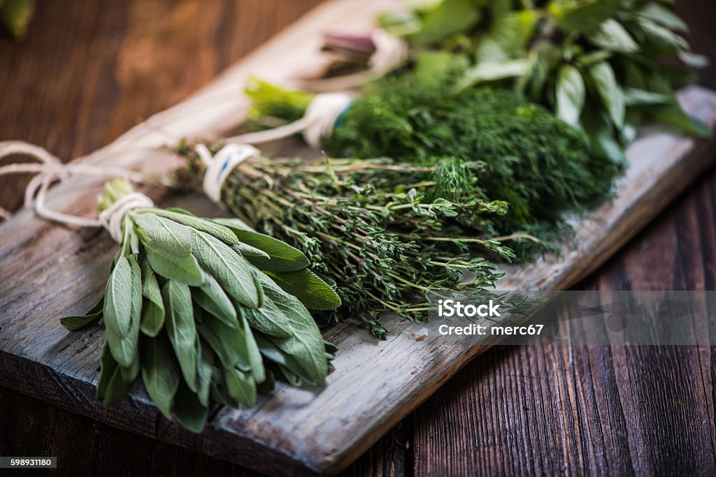 Basil,sage,dill,and thyme herbs Basil,sage,dill,and thyme herbs on wooden board preparing for winter drying Herbal Medicine Stock Photo