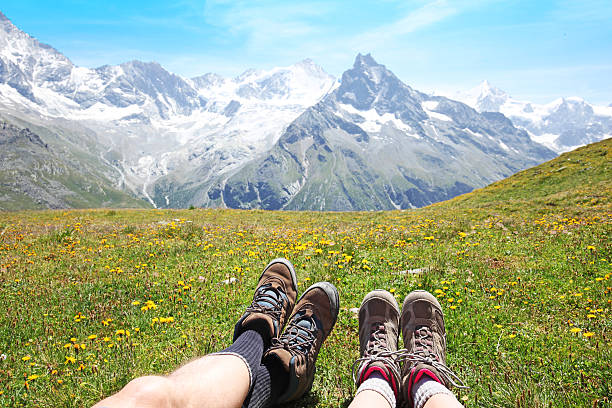 스위스 산맥의 야생화 초원에 누워 있는 두 명의 등산객 - switzerland hiking boot outdoor pursuit recreational pursuit 뉴스 사진 이미지