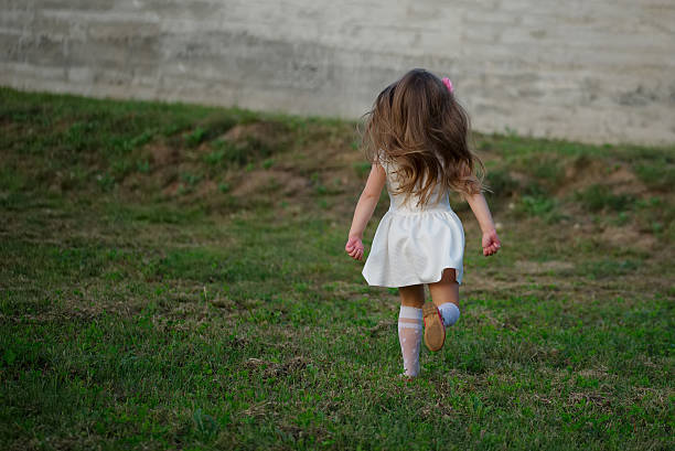 photo of little beautiful running girl outside