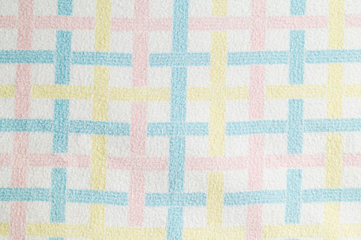 A pastel colored vintage bably blanket.