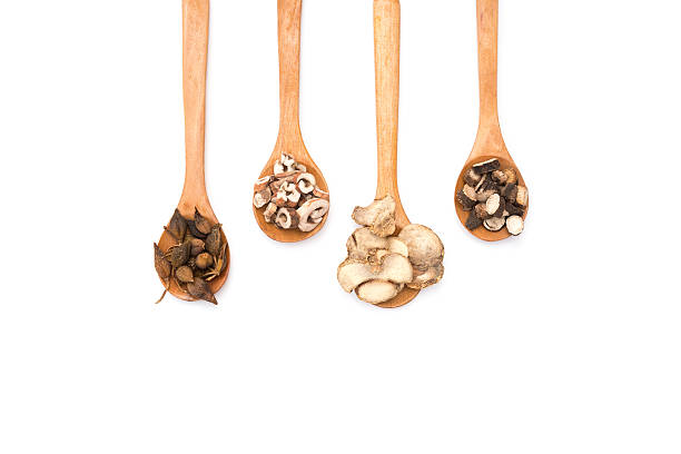 chinese herbs on wooden spoons at a white background chinese herbs on wooden spoons at a white background shiso photos stock pictures, royalty-free photos & images