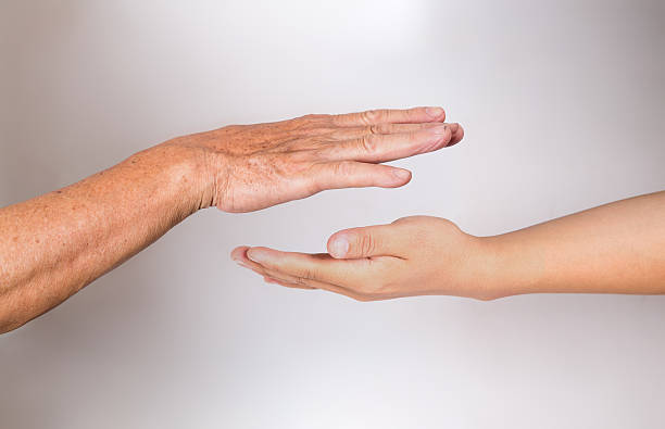 istock old man with young man's hand together 598949502