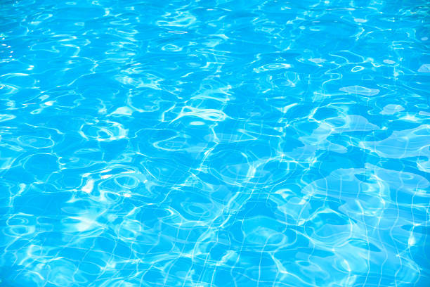 istock Bright water in swimming pool with sun reflection 598950062