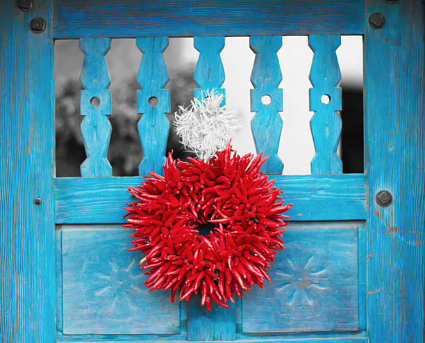 santa fe stil: chili pfeffer ristra kranz auf blaue tür - wreath chili pepper pepper ristra stock-fotos und bilder