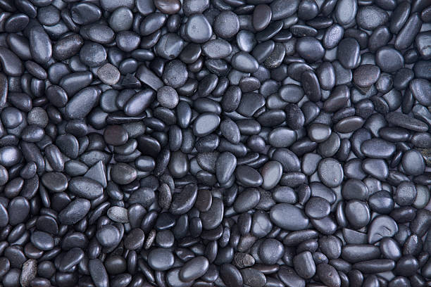 Background texture of waterworn black pebbles stock photo